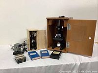 Overview of two microscopes, slide boxes, and accessory box displayed on a table.
