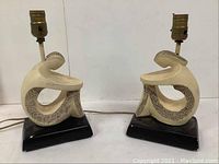 Pair of vintage bedside table lamps with abstract cream ceramic sculptural bodies on black bases, showing both from front and side views.