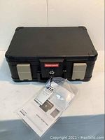 Closed Honeywell Fire & Water Chest with manual and keys in front.