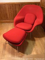 Full view of red Womb chair with ottoman in room