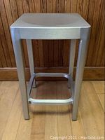 Front view of the aluminum stool showing the 'emeco by starck' engraving on the front edge