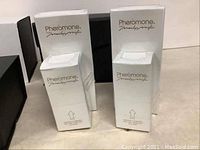 Signed and boxed Marilyn Miglin Pheromone perfume bottles in original white and black packaging in unopened condition.