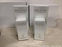 Two white boxed Marilyn Miglin Destiny perfume bottles, unopened and standing upright.