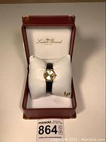 Watch in original Lucien Piccard box on white cushion.