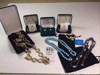 Full shot showing all seven jewelry pieces including necklaces, bracelets, earrings alongside their boxes and pouches