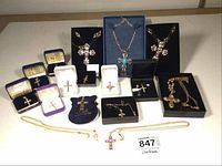 Wide view of all 16 crucifixes arranged on table, some in display boxes