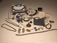 Overview of entire assortment of 30 jewelry pieces including necklaces, bracelets, earrings, and brooches in sterling and vintage costume styles.