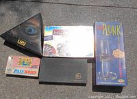 Photo showing Kerplunk, Monopoly, Password card game, and UBI black triangular box