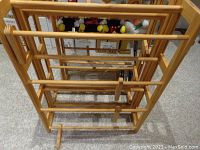 Three wooden shelves shown side by side on carpeted floor, viewed from above. Each shelf consists of a natural wood frame with multiple horizontal slats for storage.