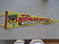 Yellow triangular pennant with Yogi Bear image and Jellystone Park Camp Resort text.