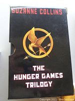 Front of slipcase featuring Suzanne Collins' name, The Hunger Games Trilogy title, and gold Mockingjay emblem.