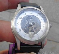 Close-up of the Harry Potter watch face showing Harry with a wand and Hogwarts emblem.
