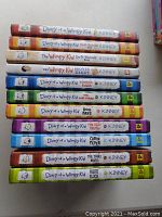 Stack of 11 Diary of a Wimpy Kid books showing colorful spines with series title, author, and individual book titles.