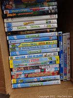 Stack of DVD cases showing titles like Shrek 2, Ice Age, Madagascar, and others