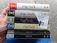 Photo showing five Nip/Tuck DVD season cases stacked together, clearly labeled Seasons 1 through 5