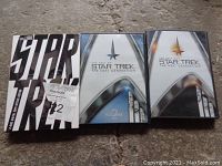Photo of three Star Trek DVD sets including original series and The Next Generation volumes 1 and 2.