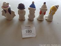 Front view of the five Goebel figurines arranged in a line on white surface, no chips visible.