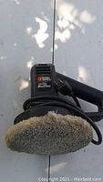 Front view of Black & Decker Handy Buffer showing the brand, model name, and attached wool buffing pad.