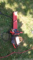 Full image of Craftsman electric worklamp laying on grass with red adjustable stand and electric cord.