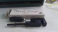 Photo of the pneumatic panel crimper with its original white box labeled 'Air Panel Crimper' on a light-colored surface.