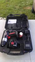 Photo showing Jobmate cordless drill kit including drill, battery, charger, and black molded plastic carrying case.