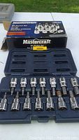 Photo of the Mastercraft bit socket set with sockets arranged in blue plastic case and original box behind, showing 14 sockets of various bit sizes.