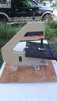 Side view of beige Black & Decker band saw with flat black work surface and blade.