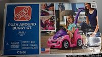 Box packaging showing the Step2 Push Around Buggy GT with image of toddler sitting in the pink buggy and adult pushing it using the rear handle.