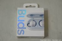 Front view of retail box showing white Samsung Galaxy Buds earbuds in charging case and holographic text 'Buds'