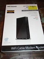 Front photo of box showing Netgear AC1750 WiFi Cable Modem Router with model number C6300, highlighting DOCSIS 3.0 cable modem functionality and compatibility with major cable providers.