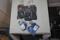 Photo showing five Tommy Copper compression wear items on a white surface including black sleeves and blue socks or sleeves, all sealed in packaging.