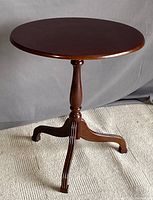 Front view of the table showing oval top and tripod base.