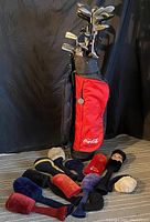 Photo of full golf bag with clubs and headcovers on floor