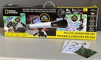 Photo of the boxed National Geographic Deluxe Adventure Set showing telescope, microscope, and binoculars with text highlighting magnifications and features.