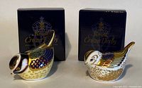 Front view of both paperweights with original Royal Crown Derby boxes positioned behind.