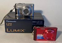 Samsung red digital camera and Panasonic Lumix DMC-LZ2 on box
