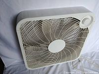 White square window fan, front angled view showing circular control dial top right.