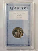 Overall photo of the 1982D US Half Dollar coin in AACGS plastic holder showing grading label MS65