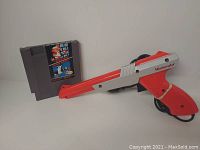 Nintendo NES game cartridge featuring Super Mario Bros and Duck Hunt next to Duck Hunt Zapper light gun
