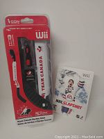 Team Canada themed hockey stick accessory for Nintendo Wii in original packaging, showing stick shape and branding.