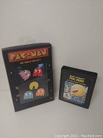 Pac-Man Retro pin set packaging with five enamel pins and Atari 2600 Pac-Man game cartridge side by side