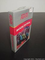 Front angled view of the sealed Moon Patrol box showing Atari and game title with lunar vehicle art