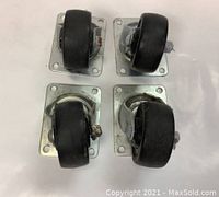 Set of 4 heavy duty dolly wheels laid out on a white background, showing the rubber tires and metal mounting plates.