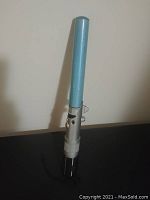 Full view of the toy light saber showing the silver handle with black details and blue blade attached.
