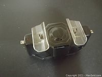 Top view of the black PS3 controller charging dock showing the dual controller ports with clear plastic guards.