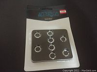 Front view of pack of 9 silver metal curtain rings in retail packaging
