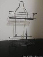 Front view of two-tiered wireframe bathroom holder showing shelves and hanging hook.