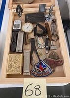 Top view showing all items, including belt buckle, pocket watch, lighters, figurines, and patch
