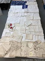 Full view of the assorted linens laid out on a bed showing various sizes and embroidery styles.