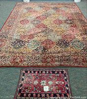 Full view showing both large and small rugs on showroom floor